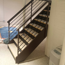 Custom-made metal railings add a contemporary look to these basement stairs.
