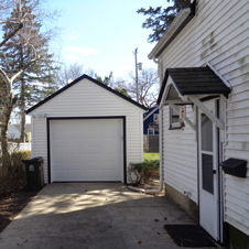This free-standing garage improves usable driveway area and matches the exterior of the home.