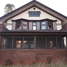 This porch is enclosed in screens and has details replicated from historical photos.